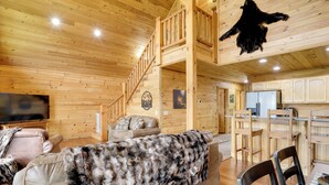 Ein Holzhaus-Interieur mit Wohnzimmer, Küche und einer Treppe.