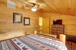 A wooden cabin room with a bed, a ceiling fan, a dresser, and a television. - Peaceful 2-cabin Property: 1 Mi to Current River! (Van Buren)