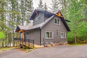 A two-story cabin with a deck, large windows, and a chimney. - Lakeside Bliss in Tahuya! Modern Family Getaway (Tahuya)