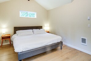 A bedroom with a bed, bedside lamps, a window, and a wall-mounted vent. - Lakeside Bliss in Tahuya! Modern Family Getaway (Tahuya)