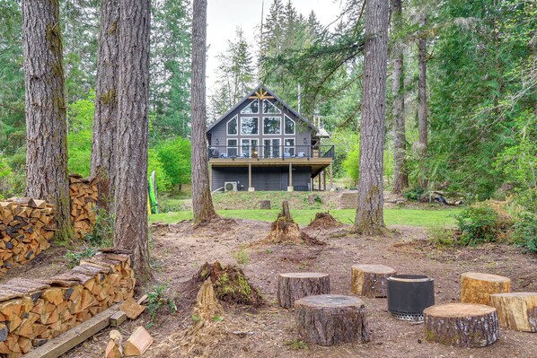 A cabin surrounded by trees with a deck and a fire pit area. - Lakeside Bliss in Tahuya! Modern Family Getaway (Tahuya)