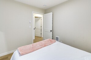 A bedroom with a bed, a door, and a hallway. - Lakeside Bliss in Tahuya! Modern Family Getaway (Tahuya)