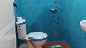 Un baño pequeño con inodoro, ducha y lavamanos.
