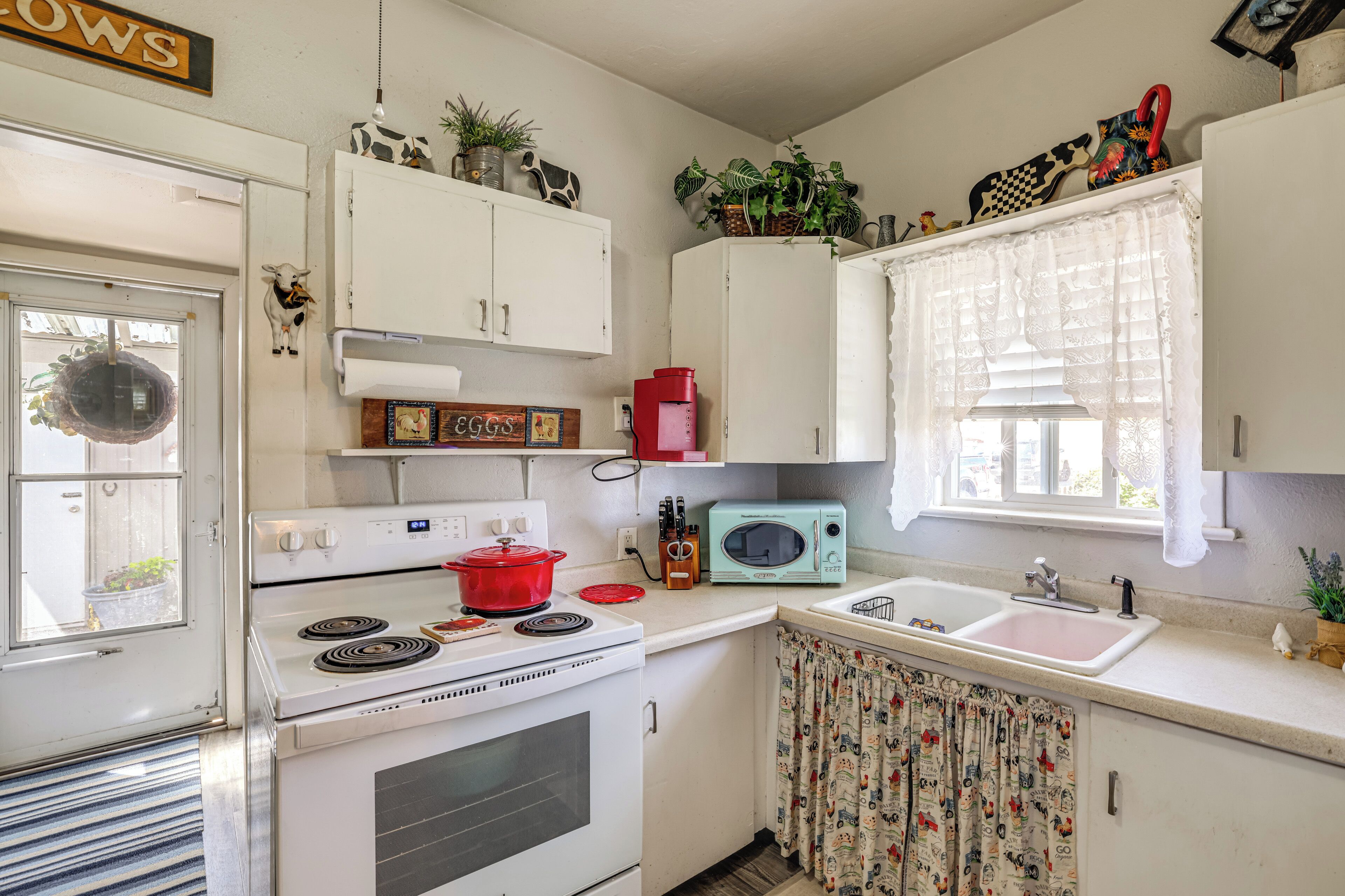Una cocina equipada con estufa, microondas, lavaplatos y armarios.