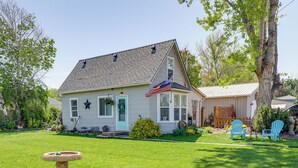 Ein Haus mit einer Veranda, einem kleinen Garten und einem Vogelbad.