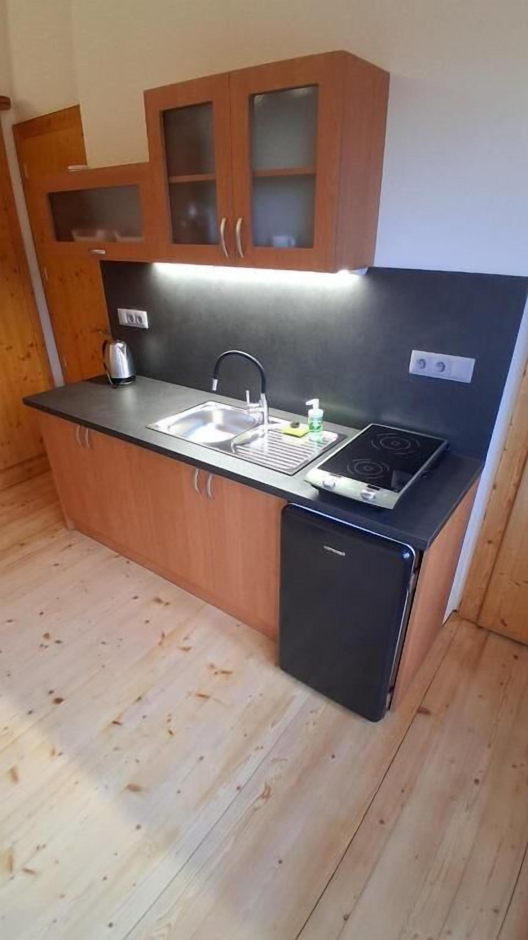 Una cocina compacta con fregadero, estufa y armarios de madera.