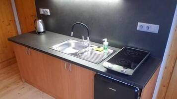 Una cocina compacta con fregadero, estufa y armarios de madera.
