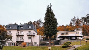 A multi-story building with balconies, a stone facade, and a covered outdoor area.