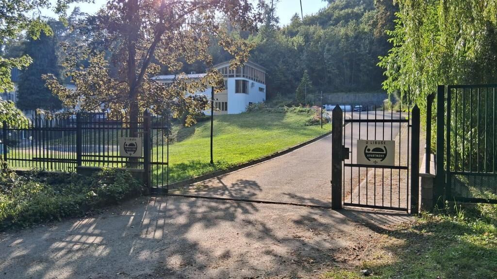 Ein begrenzter Eingang zu einem Gebäude, an dem ein Schild die Bezeichnung ULBUSE Apartment trägt.