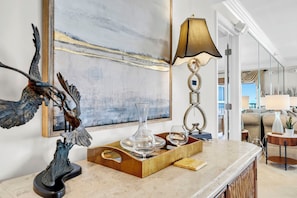 A marble countertop with a bird sculpture, a lamp, and a tray with glasses and a vase. - Remodeled🌴🌴Beachfront🌊🌊Sunset View☀️☀️8th Floor⛱️⛱️Destin Towers (Destin)