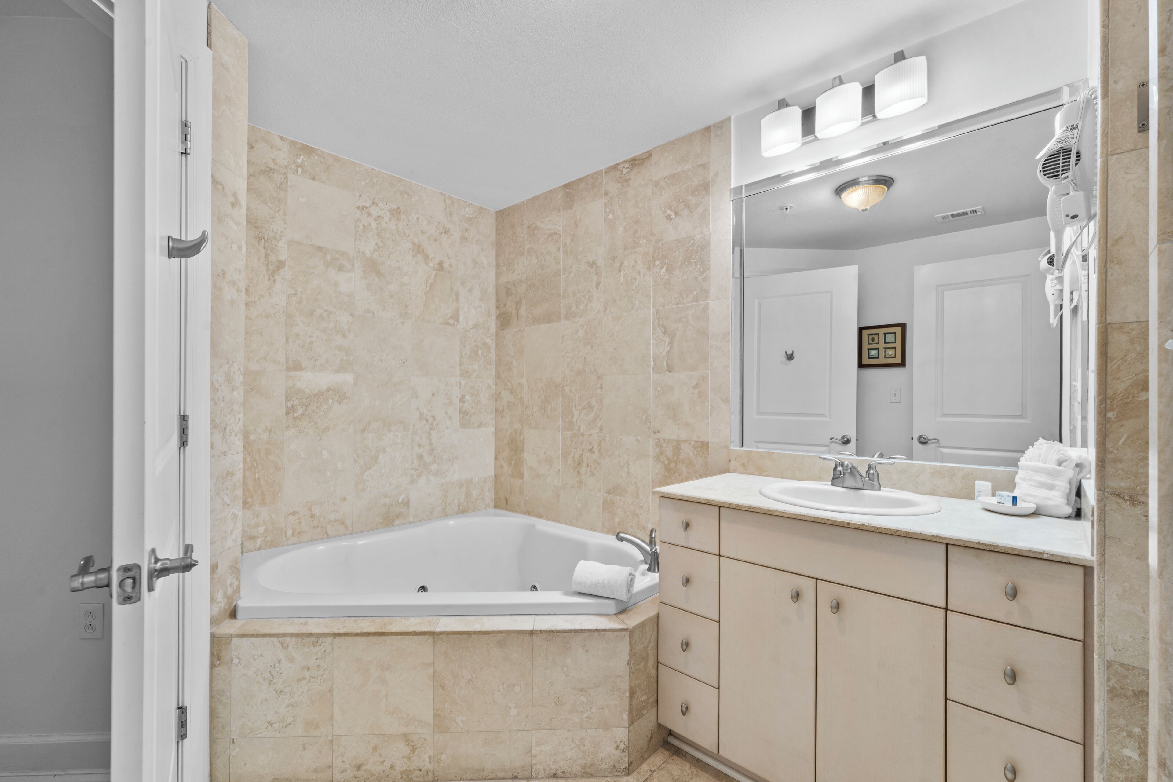 Un baño moderno con bañera, tocador y un espejo grande.