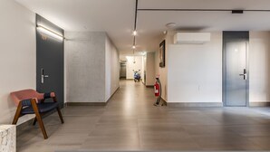 A hallway with a fire extinguisher, a scooter, and a door labeled '109'. - Brown Studio 116 Love in Colours Collection (Durrës)
