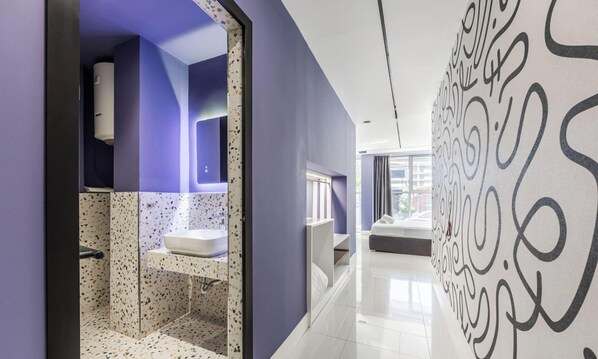 A modern bathroom with a white sink, a mirror, and a shower area. - Violet Studio 113 Love in Colours Collection (Durrës)