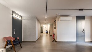 A hallway with a fire extinguisher, a chair, and a door marked '109'. - Rose Studio 112 Love in Colours Collection (Durrës)