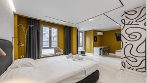 A modern hotel room with a large bed, a desk, and a chair. - Honey Studio 115 Love in Colours Collection (Durrës)