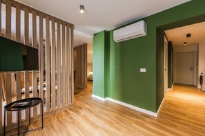 Ein Zimmer mit Holzwand, einem Bett, einer Waschmaschine und einer Klimaanlage.