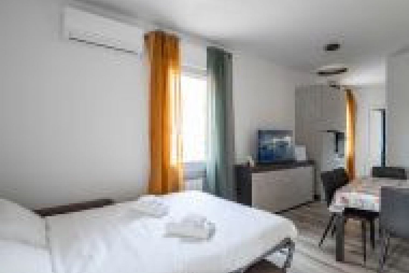 A hotel room with a bed, a desk, and a chair.