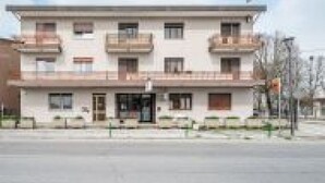 A multi-story building with balconies, a central entrance, and a flat roof. - GuestHost - San Vincenzo Apartment 2 Vigonza (Peraga)