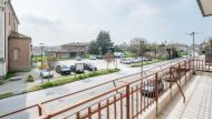 A street view with buildings, a sidewalk, and parked cars. - GuestHost - San Vincenzo Apartment 2 Vigonza (Peraga)