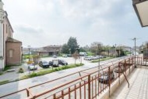 Una vista di strada con edifici, un marciapiede e auto parcheggiate.
