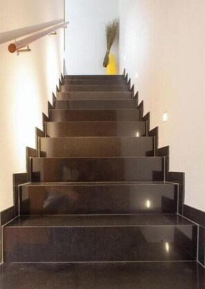 A staircase with a handrail and a vase with dried plants at the top. - Villa Noomi - Elegant design villa with mountain views, garden & fireplace in Frastanz (Frastanz)