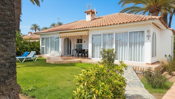 A two-story house with a tiled roof, a covered porch, and a well-maintained lawn. - BUNGALOWS SUN CLUB (San Bartolomé de Tirajana)