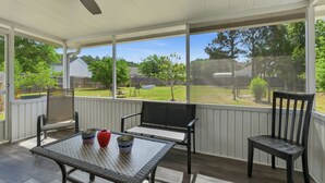 A covered patio with a table, chairs, and a ceiling fan. - Ideal Dream Getaway 4 Bedroom Home (Savannah)