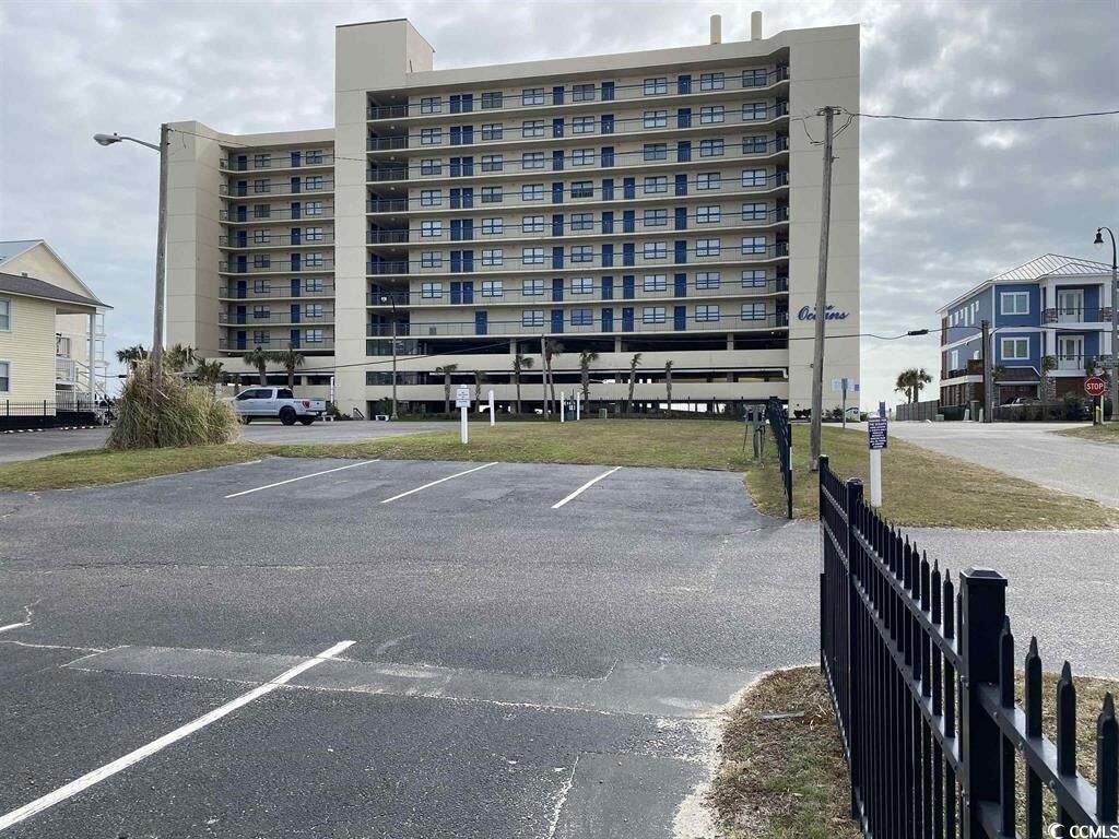 Un hôtel à plusieurs étages avec un parking situé à l’avant.