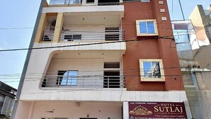 Un edificio de varios pisos con un letrero que dice 'Sutlej Hotel'.