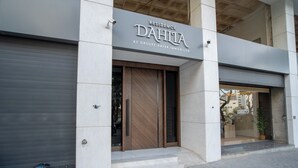 Ein Gebäude mit einem Schild, auf dem 'Residence Dahia by Groupe Afer Immobilier' steht, und einer geschlossenen Garagentür.
