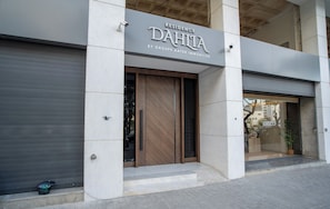 A building with a sign reading 'Residence Dahia by Groupe Afer Immobilier' and a closed garage door. - 2-bedroom apartment with terrace,  minutes to shopping, train, restaurants. (Tangier)