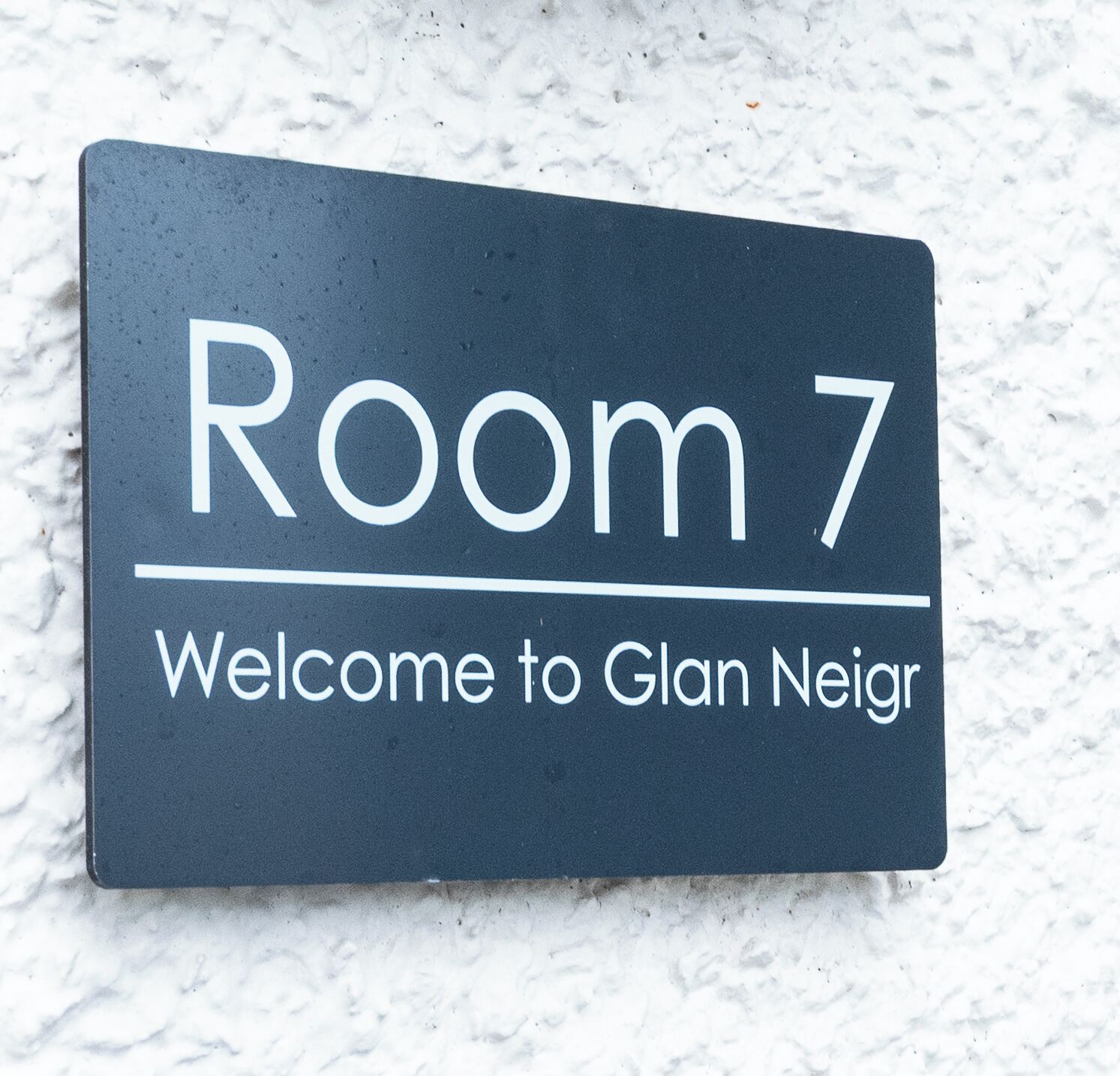 A sign for 'Room 7' with the text 'Welcome to Glan Neir.'
