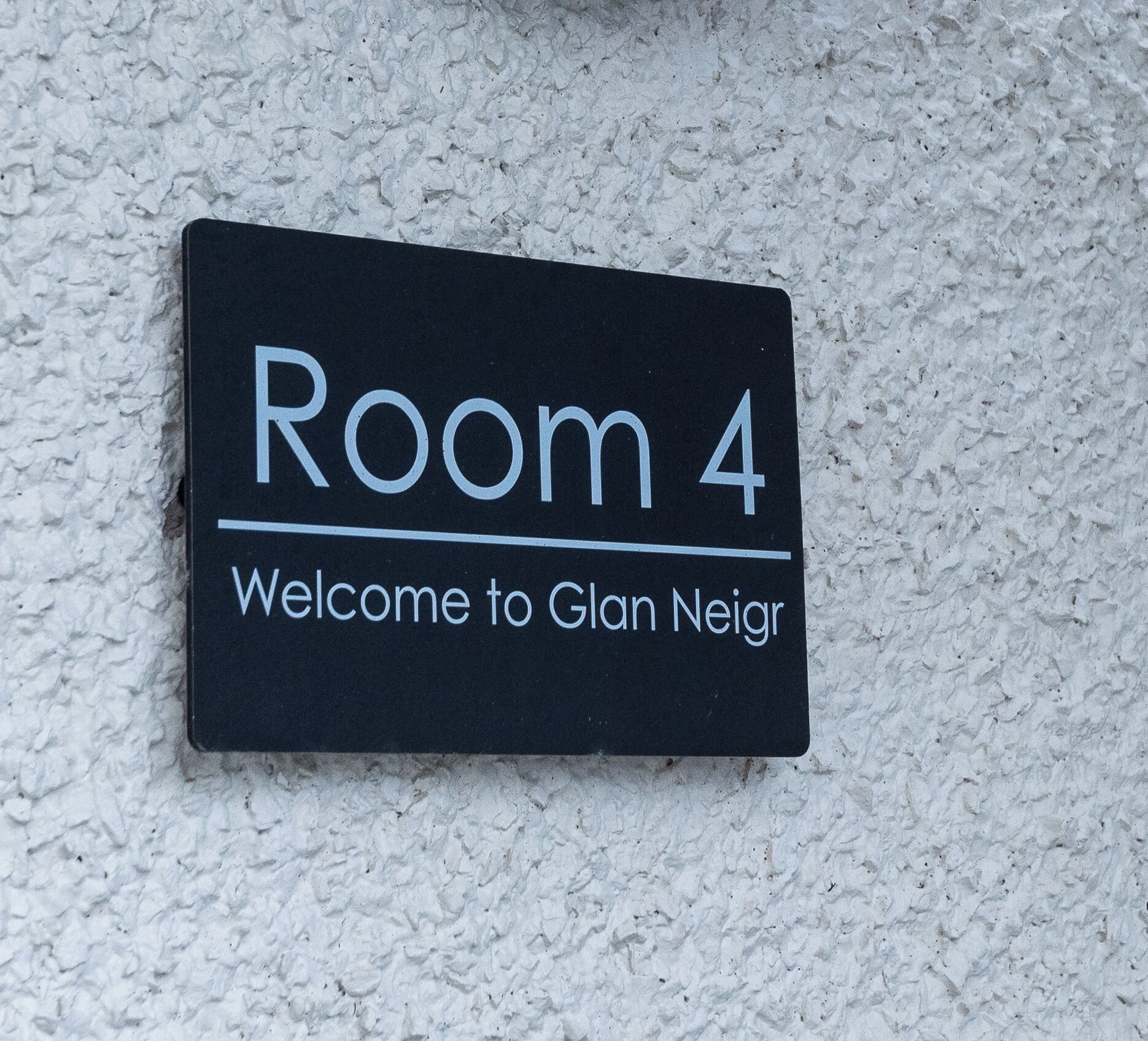 A sign indicating 'Room 4' with a welcome message to 'Glan Neir'.