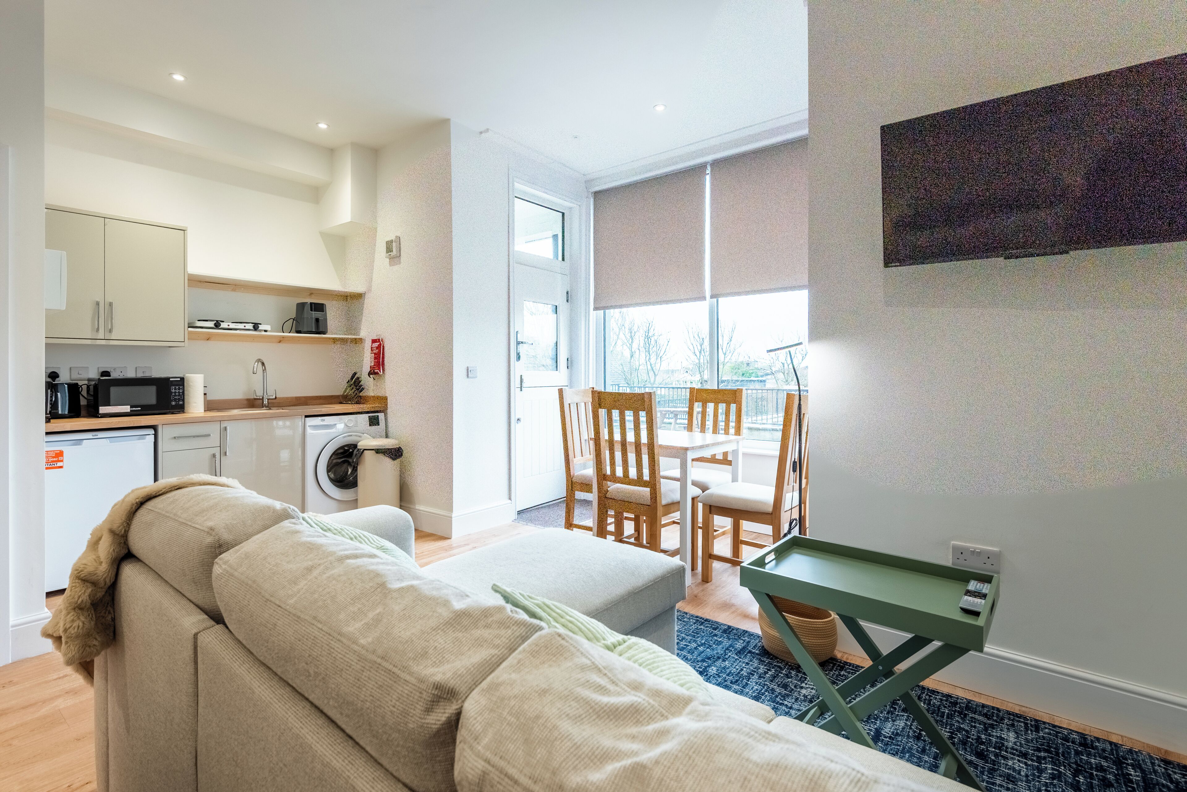 A compact living space with a kitchenette, a dining area, and a sofa.
