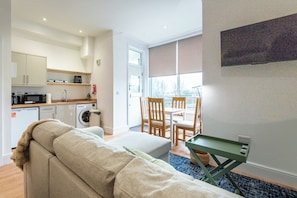 A compact living space with a kitchenette, a dining area, and a sofa.