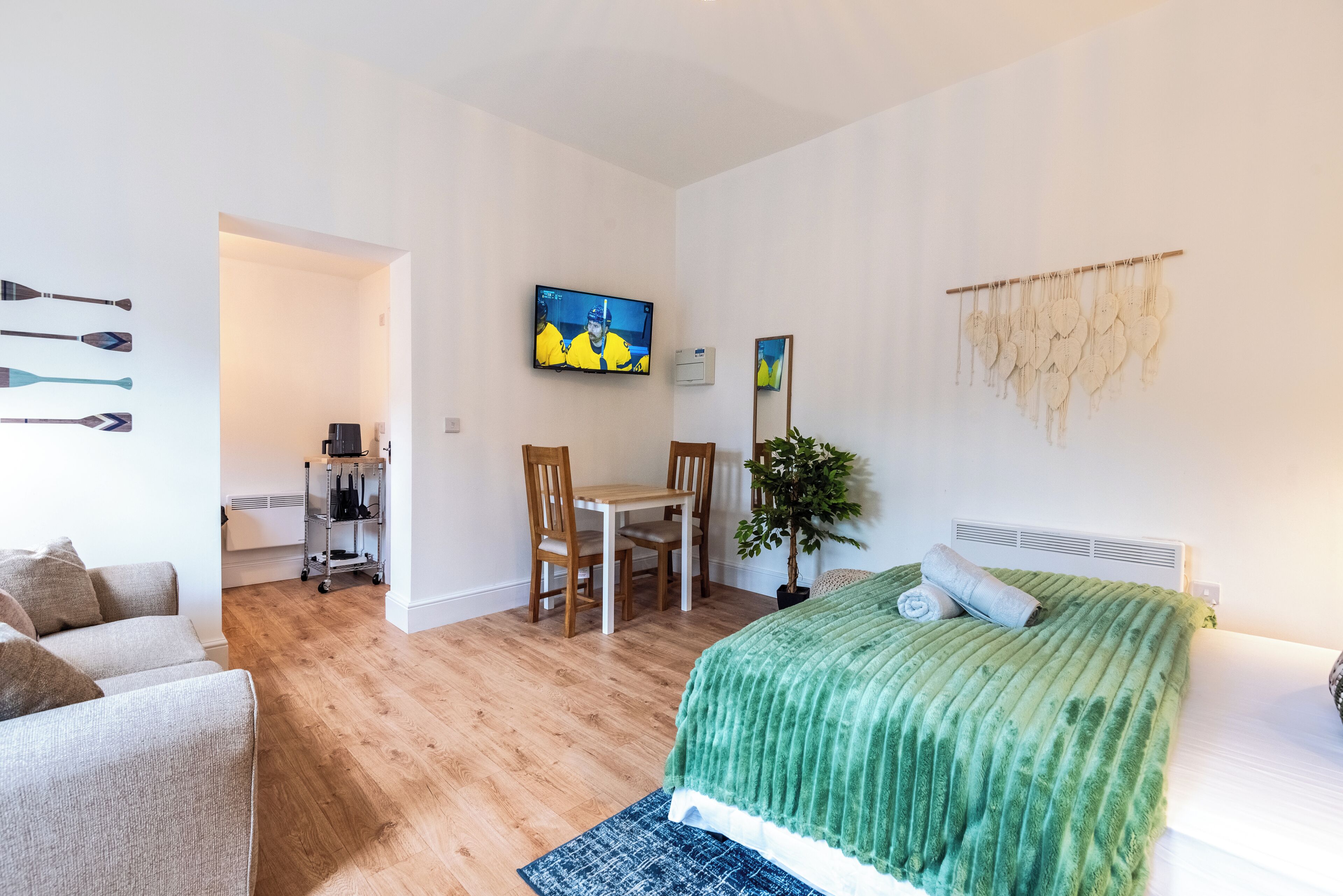 Quarto de hotel moderno com cama, escrivaninha e televisão.