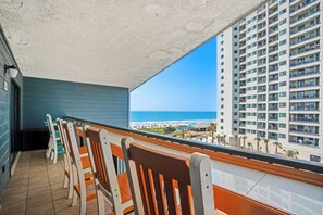 A balcony with chairs overlooking a beach and a high-rise building. - 2 BR Ocean View Condo | Myrtle Beach Resort B0514 (Myrtle Beach)