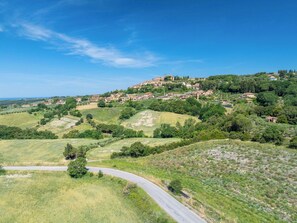 Un village perché sur une colline, doté d’une architecture traditionnelle, traversé par une route sinueuse et entouré d’une végétation luxuriante.