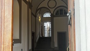 Ein Flur mit Treppe, gewölbter Decke und einem gemusterten Boden.