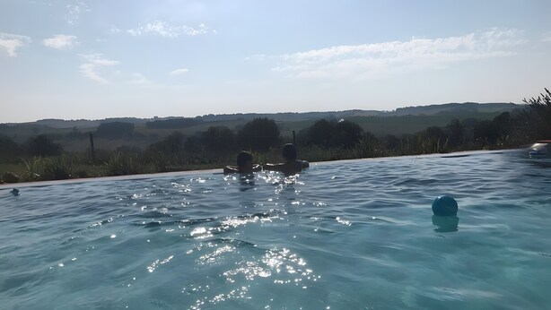 A swimming pool with clear water, surrounded by a landscape view.