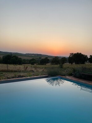 Piscina com vista desobstruída do pôr do sol sobre o interior.