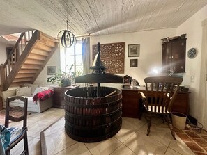 Un accogliente soggiorno con una scala in legno, un tavolino con una lampada e una libreria.