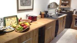 A kitchen with wooden cabinets, a coffee machine, and a fruit bowl on the counter.