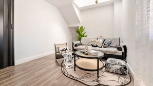 Un salon moderne avec un canapé, une table basse et un tapis à motifs.
