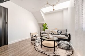 Ein modernes Wohnzimmer mit Sofa, Couchtisch und einem gemusterten Teppich.