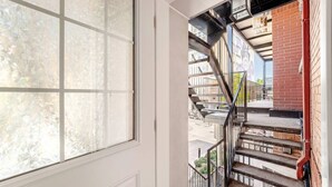 Un escalier avec des rampes en métal menant à un espace extérieur.