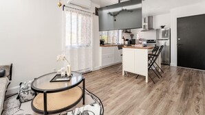 Un appartement moderne comprenant un coin repas, une cuisine et un espace de vie.