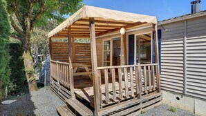 A wooden deck with a canopy, a small porch, and a window.