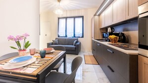 Una cocina moderna con comedor, sofá y ventana con cortinas.