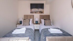 A twin room with two beds, nightstands, lamps, and a painting on the wall. - Old Dutch Embassy by Guestz (Hull)